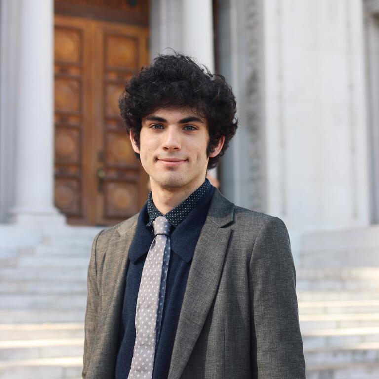 Photo of Liam McDonough on the steps of Hearst Memorial Mining Building at UC Berkeley